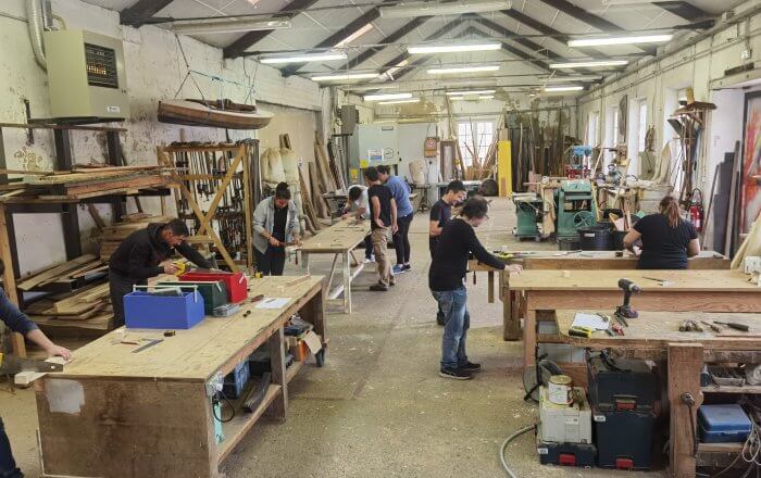 Photo d'un atelier bois avec quelques personnes travaillant